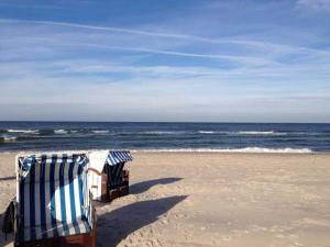 奥茨塞巴德·迪尔哈根DUENENBLICK App Nr 4 max 4 Pers的沙滩上的两把沙滩椅