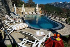 拉维罗花园酒店的一个带躺椅、桌子和桌子的游泳池
