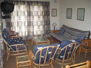 塞吉菲尔德Elfransa Beach Cottage的客厅配有椅子、沙发和电视