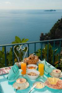 波西塔诺Hotel Il Gabbiano的一张桌子,在阳台上提供早餐食物,阳台上享有海景