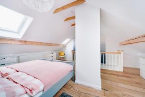 布劳恩拉格Harzallerliebst的卧室拥有白色的墙壁和木地板,配有一张床