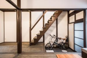 京都京町家一棟貸しKyoto Machiya Stay En的一间设有楼梯的房间,墙上有一辆自行车