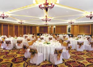 钱德加尔泰姬陵昌迪加尔酒店的宴会厅配有白色的桌椅和吊灯