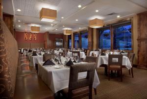 科迪Best Western Premier Ivy Inn & Suites的一间设有白色桌椅的用餐室