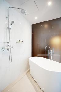 江陵市Gangneung City Hotel的白色的浴室设有浴缸和淋浴。