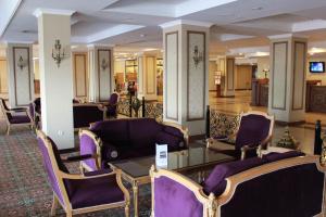 塔什干格韩德米赫酒店的大堂设有紫色椅子和玻璃桌