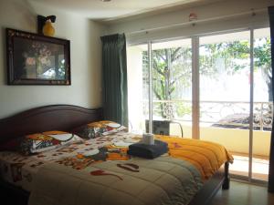 沙美岛农略客房酒店的一间卧室设有一张床和一个大窗户