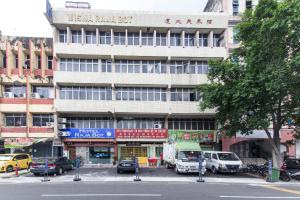 吉隆坡Hotel Raja Bot的一座大型建筑,前面有汽车停放