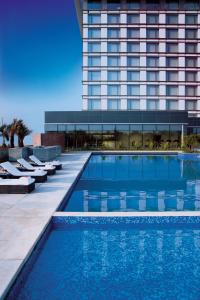 班加罗尔泰姬耶网普洱班加罗尔酒店的一座高楼前的游泳池
