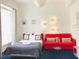 尼斯尼斯公寓的一间卧室配有一张床和一张红色的沙发