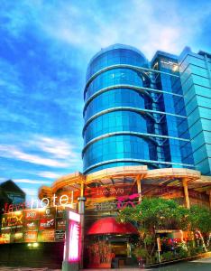 泗水favehotel MEX Tunjungan Surabaya的一座高大的玻璃建筑,前面有标志