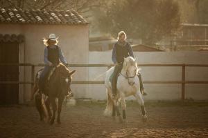 蒙图伊里Finca Caballo Blanco的两个在围栏前骑马的女人