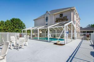 布里斯托尔Quality Inn & Suites I-81 Exit 7的一个带白色椅子的庭院和一个游泳池