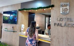 巴拉那瓜Hotel Palacio的站在生活宫餐厅前面的女人