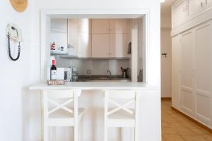 San Andrés海滩前线公寓的厨房配有白色橱柜和带凳子的台面