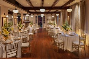 新奥尔良普罗文西奥酒店的宴会厅配有白色的桌椅和鲜花