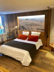 福勒恩Hôtel LAPIAZ & Spa - FLAINE的一间卧室配有一张大床和两个红色枕头
