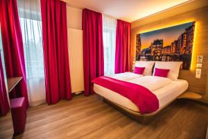 汉堡Hotel Luckys Inn的一间卧室配有一张带红色窗帘的大床