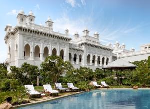 海得拉巴泰姬陵法拉克奴玛宫酒店的一座带躺椅和游泳池的大型白色建筑