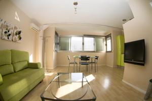 塔里法塔里法罗夫特公寓的客厅配有绿色沙发和桌子