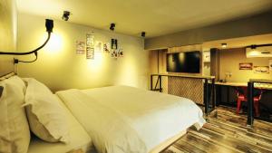 南宁胜华文创公寓的配有一张床和一台平面电视的酒店客房