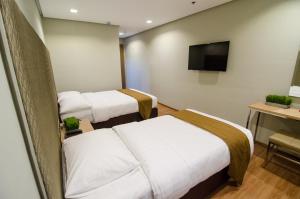 伊洛伊洛麦迪逊PHL酒店的酒店客房设有两张床和一台平面电视。