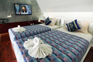 查龙普吉岛天堂旅馆的酒店客房,配有两张带毛巾的床