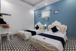 河内Hanoi Boutique House的一间卧室设有两张床和蓝色的墙壁