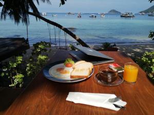 涛岛龟岛皇家度假酒店的一张带一盘早餐食品的桌子,享有海景