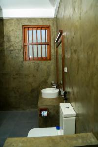 坦加拉Goyambokka Guesthouse的一间带卫生间、水槽和窗户的浴室