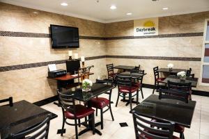 康科德康科德戴斯酒店的一间带桌椅的餐厅以及墙上的电视