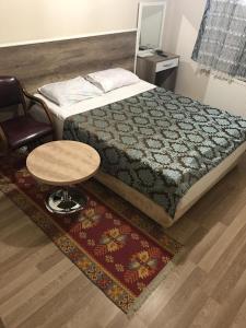 埃尔祖鲁姆凯尔万萨拉伊酒店的卧室配有1张床、1张桌子和1把椅子
