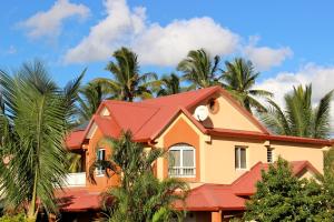 圣路易斯La Kazette - Votre Studio de Vacances à l Île de La Réunion的一座红色屋顶和棕榈树的房子