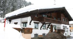 帕尔特嫩Appartment Valnova / Barga的一座带雪盖屋顶和楼梯的房子