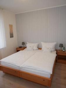巴特德里堡尼德高旅馆的卧室配有一张带白色床单和枕头的大床。
