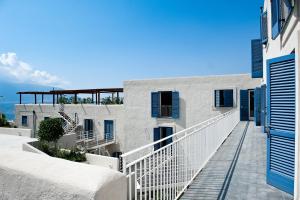 Acquacalda耐奥斯达那酒店的白色的建筑,设有蓝色百叶窗和阳台