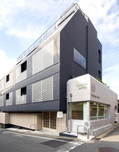 京都TSUKIMI HOTEL的黑白的建筑,前面有长凳