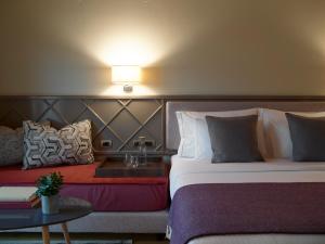 约阿尼纳The Lake Hotel的酒店客房设有两张床和一张桌子。