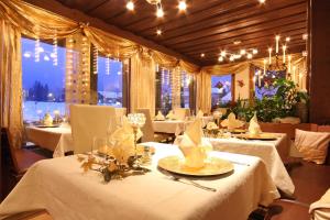 坎德施泰格瑞士博尼福品质酒店的一间设有白色桌椅和窗户的用餐室