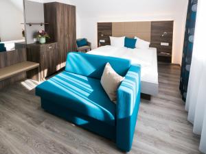 鲁斯特Hotel Löwen Garni - B&B的酒店客房,配有床和蓝色的沙发