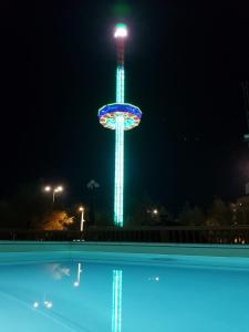 佩萨罗维托瑞亚酒店的摩天轮在晚上点燃,游泳池