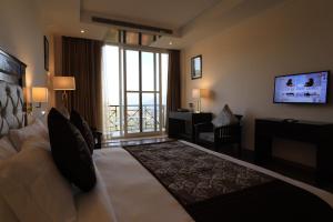 KandāghātDeventure Shimla Hills的酒店客房设有一张大床和一个阳台。