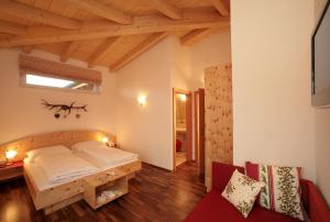 卡普伦外丹曼舍勒公寓酒店的一间带一张床的卧室,位于带木制天花板的房间内