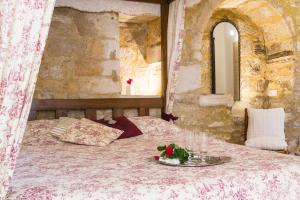 贝纳克和卡泽纳克Au coeur de Beynac, superbe maison du 16ème siècle avec jardin panoramique的一间卧室,床上放着一盘鲜花
