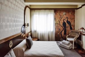 布尔戈斯马日亚路易撒酒店的卧室配有床、椅子和窗户。