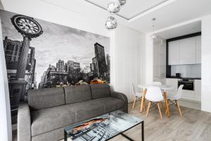 华沙Exclusive Trendy Apartments的客厅配有沙发和墙上的时钟