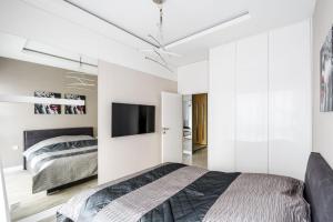 华沙Exclusive Trendy Apartments的一间卧室配有一张床和一台平面电视