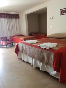 Gobernador GregoresHotel Parador Ruta 40的酒店客房,配有三张带红色床单的床