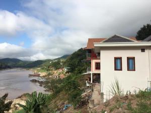 北宾Villa Mekong Guesthouse的河畔山丘上的房屋