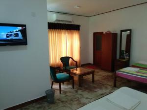 尼甘布Ocean Gate Negombo的配有床、桌子和椅子的房间